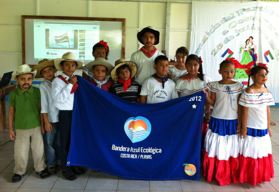 Children holding a blue banner with 'Banderá Azul Ecológica' at an event in Costa Rica