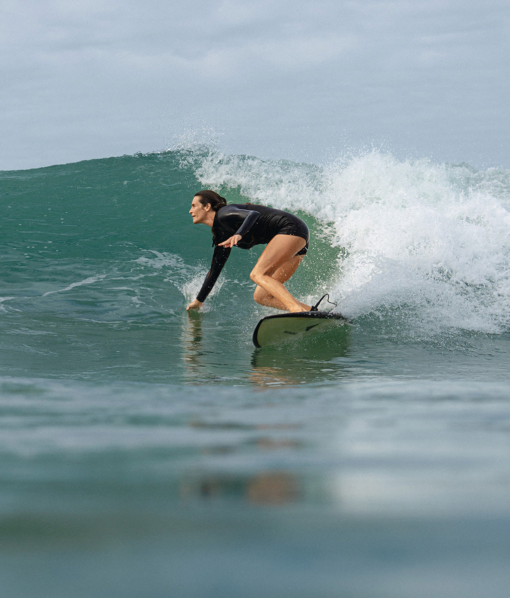 Michelle Surfing in Santa Teresa Costa Rica wearing our Dawn One Piece surf suit with sun protection
