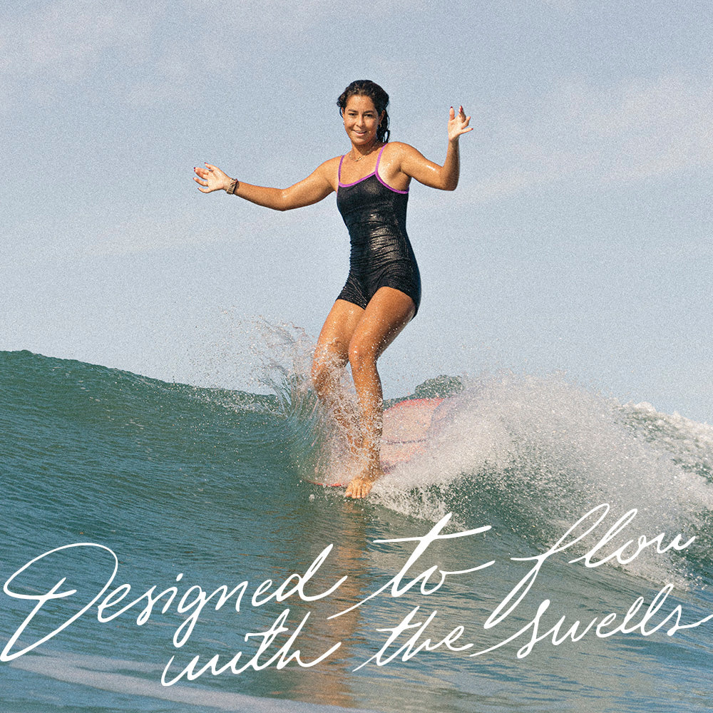 Liaz Diaz doing a sneaky five surfing in Santa Teresa Costa Rica wearing Dkoko one piece surf suit