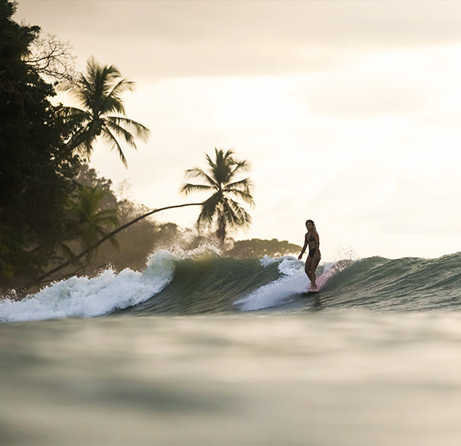 Longboarding sliding happily in a left hander in a perfect point break in Costa Rica.